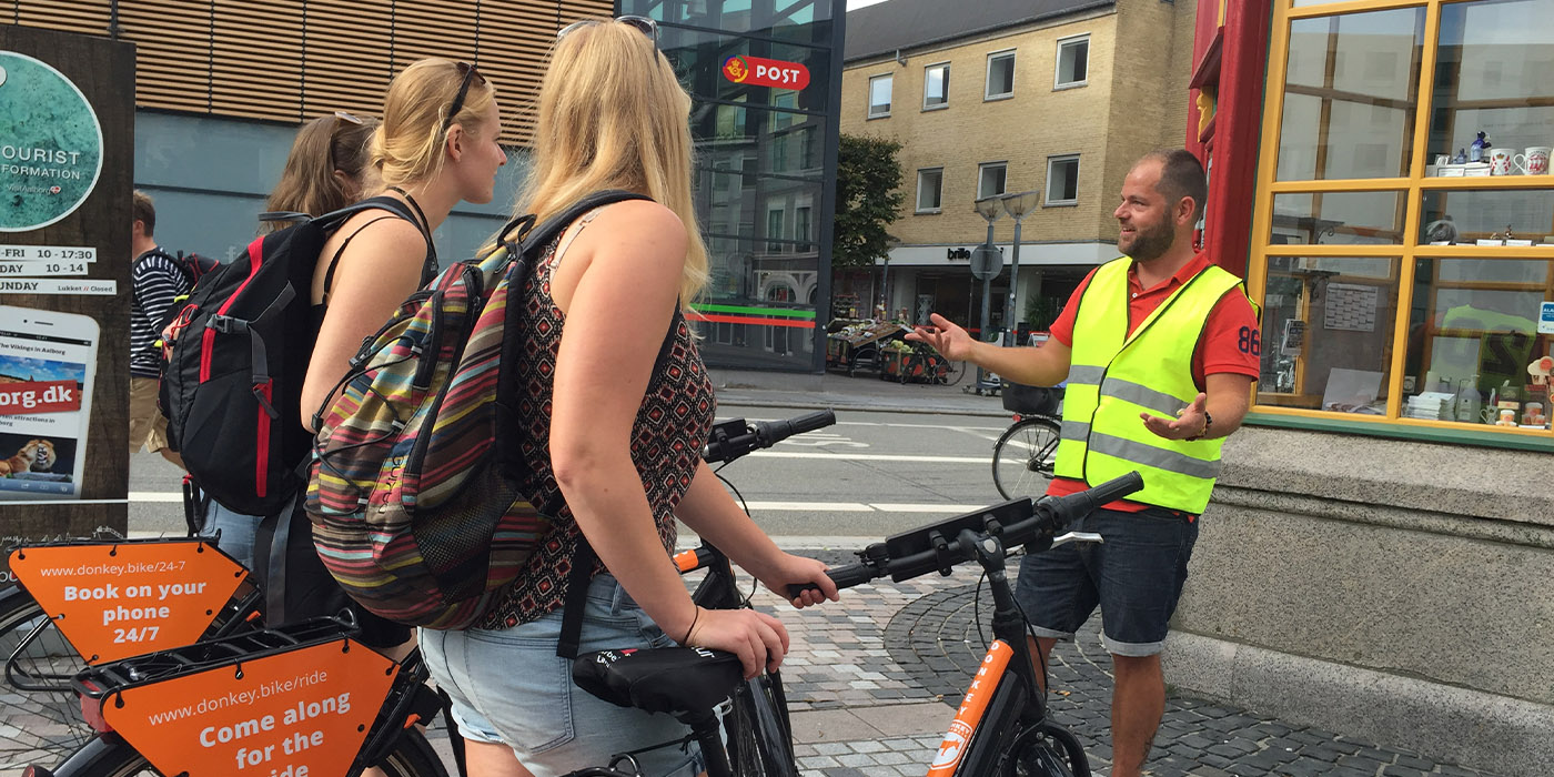 Gruppe med cykler får guided tur på Gabels Torv i Aalborg