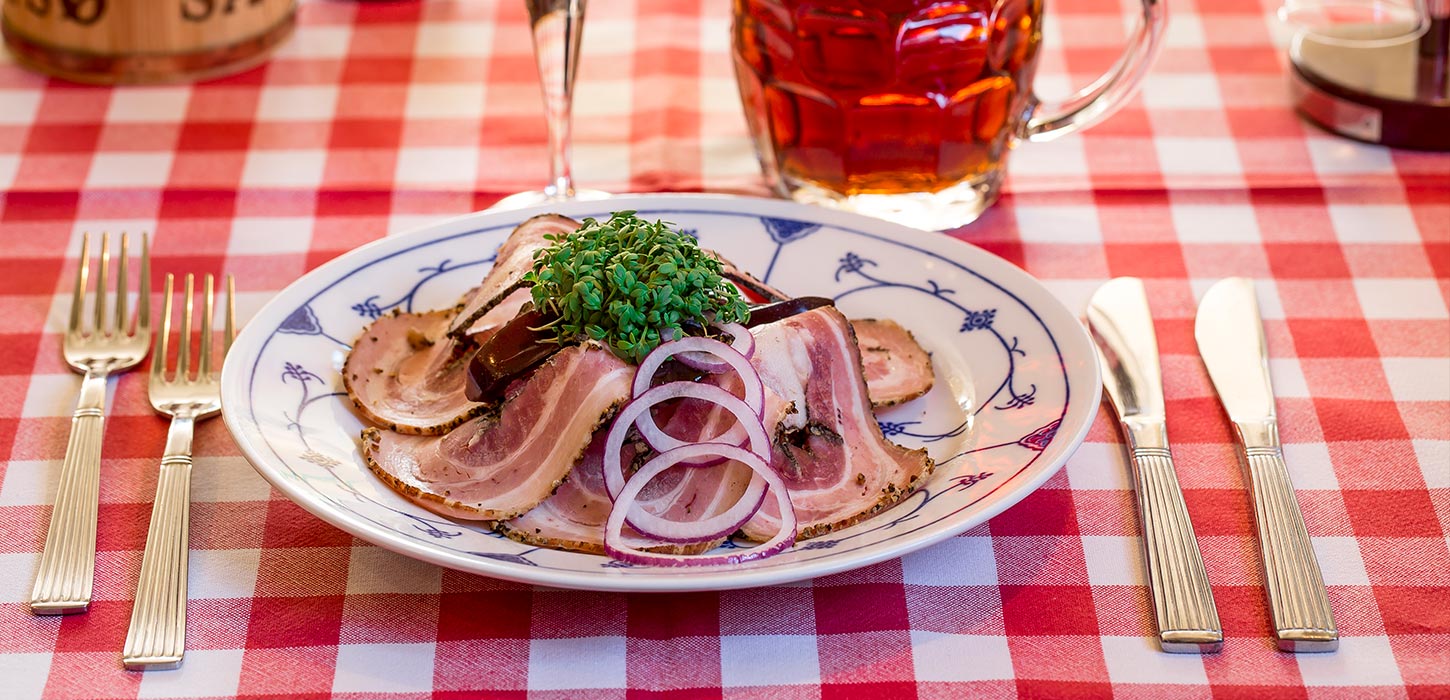 Smørrebrød rullepølse med øl og akvavit på rødternet dug