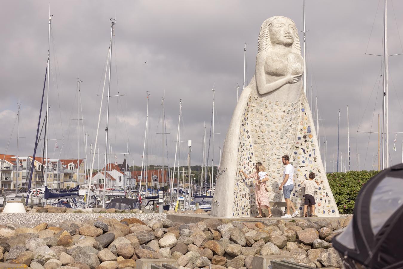 Sæby Havn med familie foran 7 meter høje statue, fruen fra havet